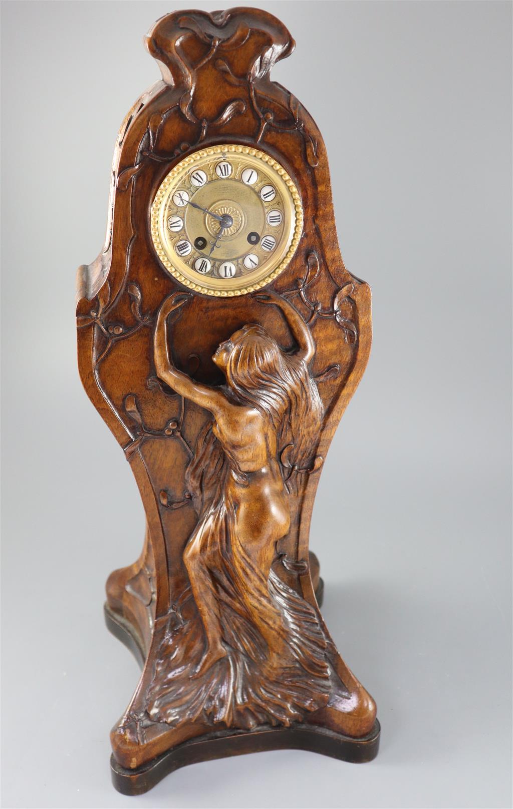 An unusual French Art Nouveau walnut mantel clock, width 9in. height 22.75in.